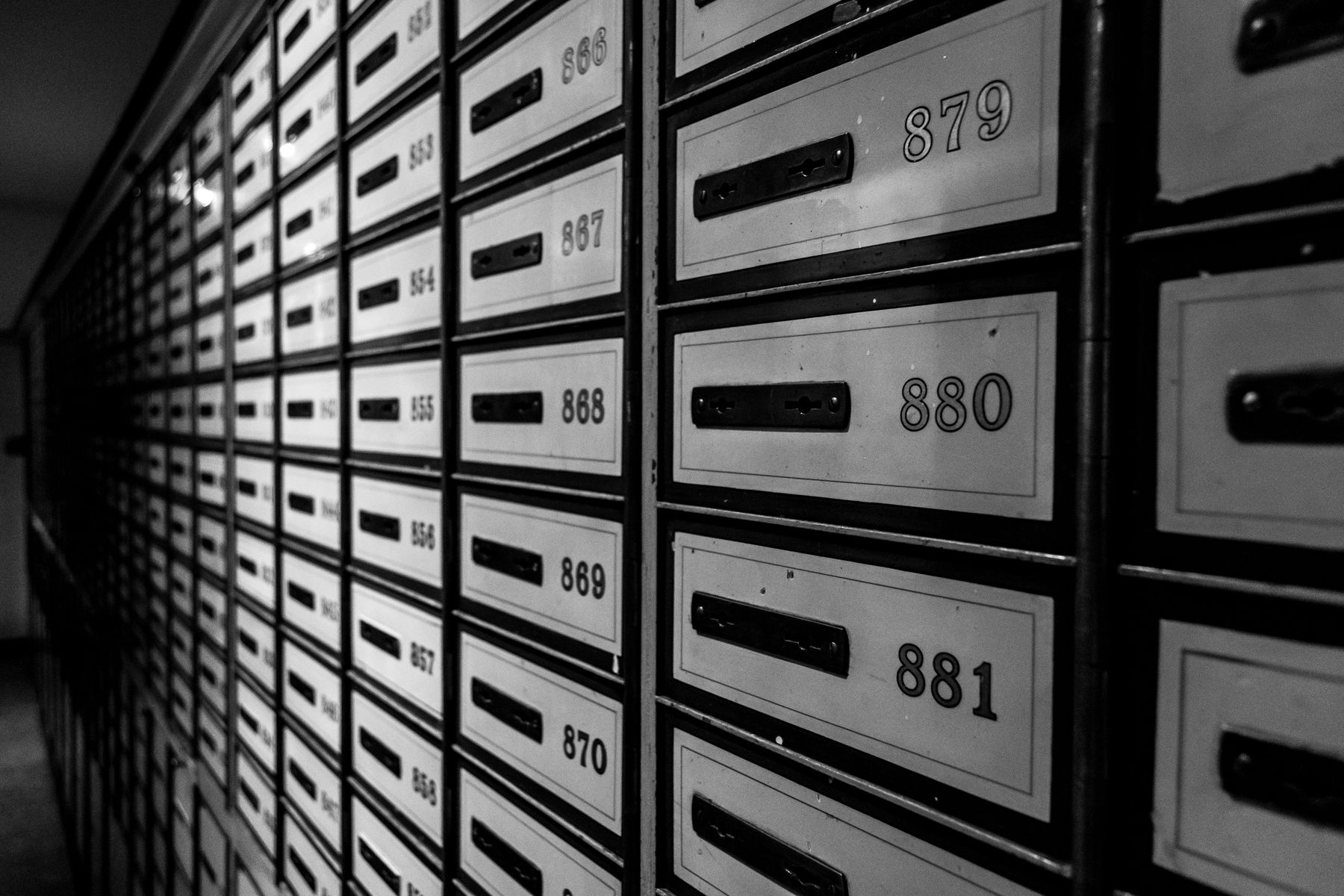 Wall of numbered safe deposit boxes with keyholes